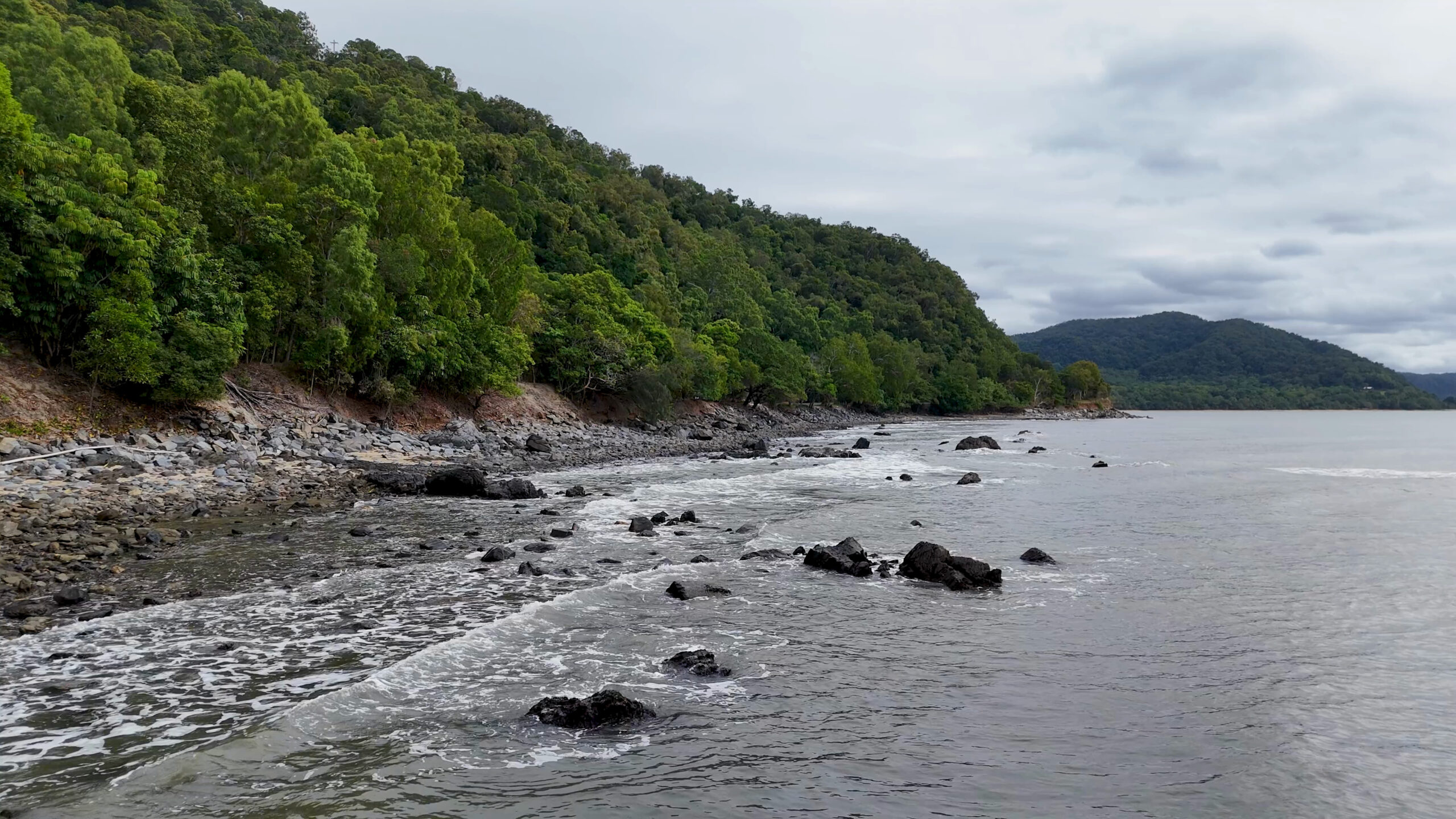 aerial-view-rocky-shoreline-lush-daintree-rainforest-wonga-beach