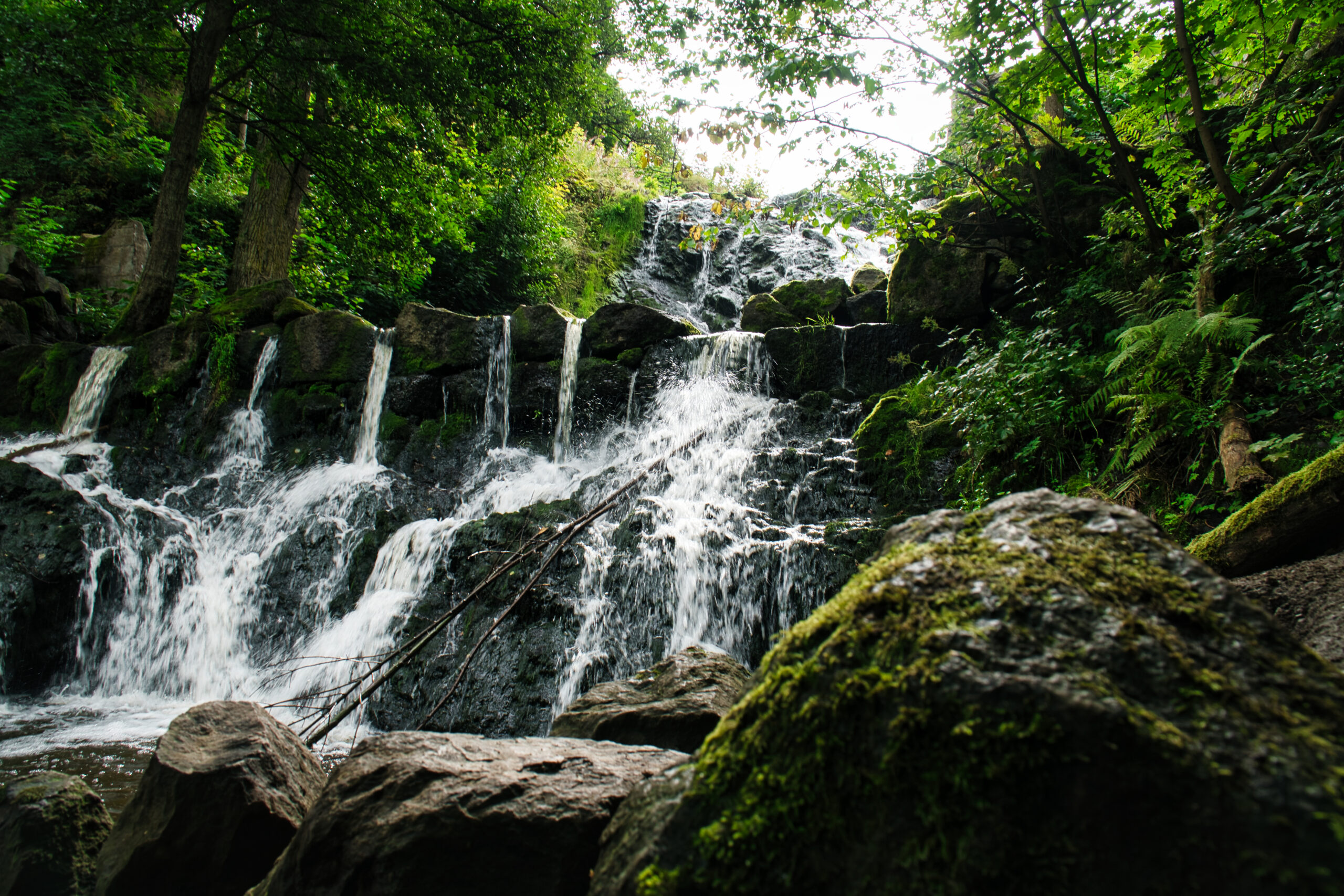 Small waterfall in Sweden. Moss-covered stones. Forest on the river bank. Scandinavian