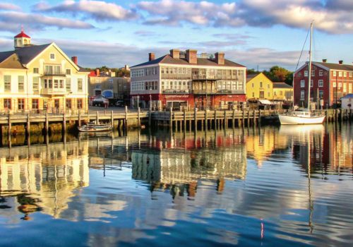 Colorful waterfront buildings reflected in calm water.