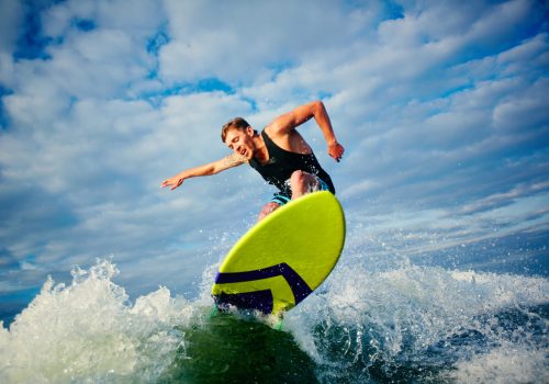 Male surfer riding on board in summer
